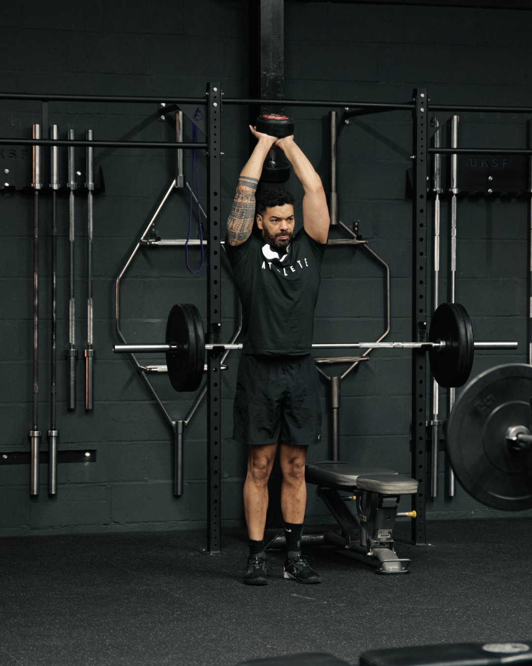 Man performing tricep dips in a modern gym, using high-quality strength equipment during an upper-body workout session